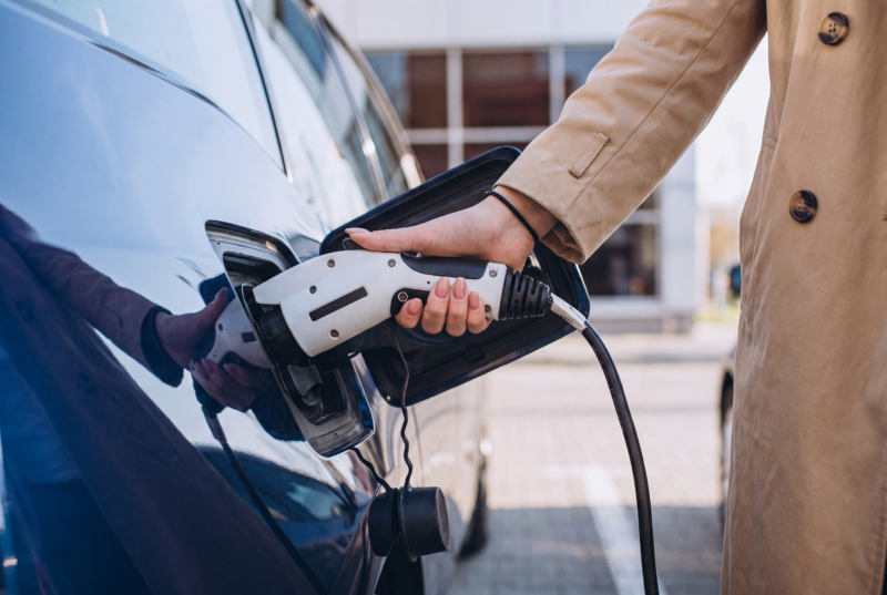 woman-charging-electro-car-electric-gas-station-scaled